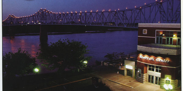 The Clover Cary Bridge at 
night with RiverPark Center in the foreground.